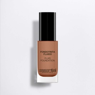 Essential Fluid Foundation in a warm medium brown shade, presented in a clear glass bottle with a black cap on a light gray background.
